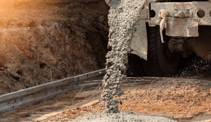 Concrete being poured from a mixer at a construction site, representing consumer applications including concrete mixing, cosmetics, and pharmaceuticals